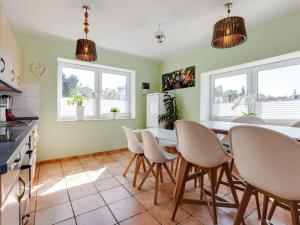 een keuken met een tafel en stoelen en 2 ramen bij Quaint Holiday Home in Kröpelin with Fenced Garden in Kröpelin