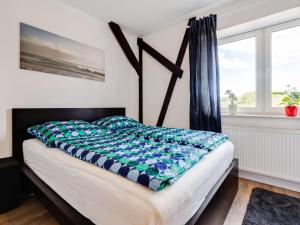 a bedroom with a bed with a blue and white comforter at Spacious Family Haven in Kröpelin in Kröpelin