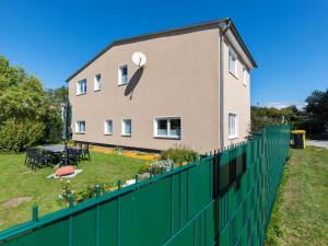 een huis met een groen hek ervoor bij Quaint Holiday Home in Kröpelin with Fenced Garden in Kröpelin