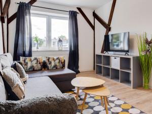 een woonkamer met een bank en een tv bij Quaint Holiday Home in Kröpelin with Fenced Garden in Kröpelin
