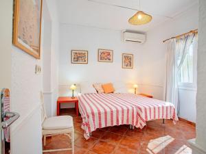 a white bedroom with a bed and a chair at Belvilla by OYO La Estrella in La Cala de Mijas