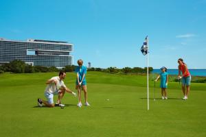 people standing on top of a lush green field at Dreams Vista Cancun Golf & Spa Resort in Cancún