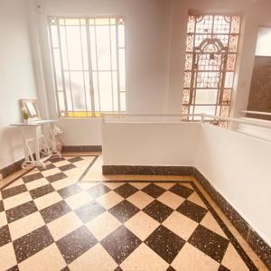 a room with a checkered floor and a window at Hospedaje de la Costa in Tigre