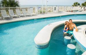 un hombre y una mujer en una piscina en Ocean Escape Condos, en Myrtle Beach