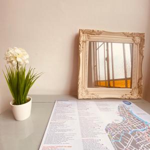 un mapa y un espejo sobre una mesa con una planta en Hospedaje de la Costa en Tigre