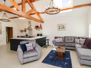 a living room with two couches and a kitchen at Kingfisher Corner in Great Driffield