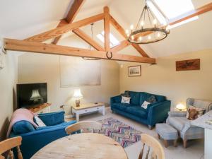 a living room with two blue couches and a table at The Stables in Great Driffield