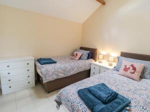 a bedroom with two beds and a dresser at The Stables in Great Driffield