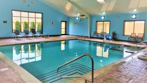 uma grande piscina com paredes e cadeiras azuis em Best Western Plus Philadelphia Bensalem Hotel em Bensalem