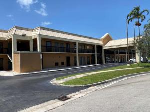 a large building with a road in front of it at SureStay Hotel by Best Western Fort Pierce in Fort Pierce