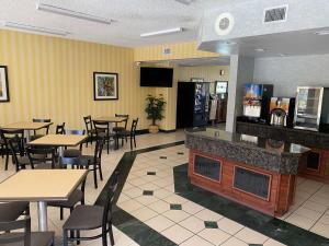 a restaurant with tables and chairs and a bar at SureStay Hotel by Best Western Fort Pierce in Fort Pierce