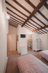 1 dormitorio con 2 camas y techo de madera en Casale di Nicolò, en Urbino