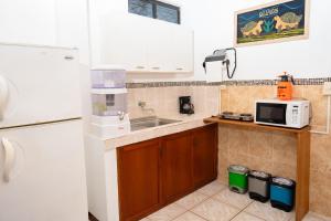 a kitchen with a sink and a microwave at Tintorera Guest House in Puerto Ayora