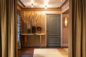 a corridor with a door and a table in a room at Hôtel Thérèse in Paris