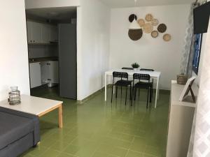 ein Wohnzimmer mit einem weißen Tisch und Stühlen in der Unterkunft Vivienda Vacacional Delia Castillo a 100 metros de la playa in Caleta de Fuste