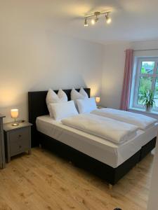 ein Schlafzimmer mit einem großen Bett mit weißen Kissen in der Unterkunft Landgasthof Alter Krug Potsdam OT Marquardt in Potsdam