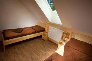 a attic bedroom with two beds and a window at Pod Břesteckou skalou in Břestek