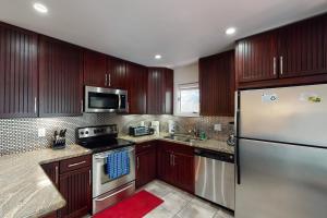 eine Küche mit Holzschränken und Geräten aus Edelstahl in der Unterkunft 70 Inlet Cove Cottage in Kiawah Island