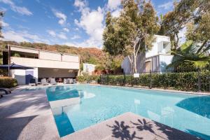 a swimming pool in front of a house at Allure Stradbroke Resort in Point Lookout