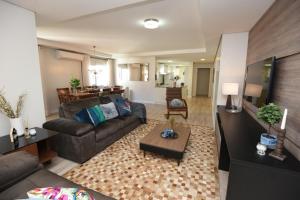 uma sala de estar com um sofá e uma mesa em APTO DE LUXO, 3 SUITES, 1 MASTER E 2 AMERICANAS, CENTRO 300mtos RUA COBERTA, GRAMADO em Gramado