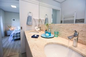 um banheiro com duas pias e um espelho grande em APTO DE LUXO, 3 SUITES, 1 MASTER E 2 AMERICANAS, CENTRO 300mtos RUA COBERTA, GRAMADO em Gramado mais 45 fotografias