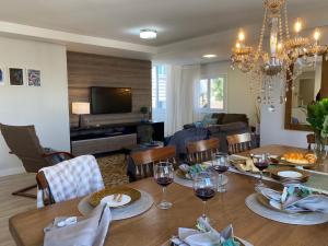 uma sala de jantar e sala de estar com uma mesa com copos de vinho em APTO DE LUXO, 3 SUITES, 1 MASTER E 2 AMERICANAS, CENTRO 300mtos RUA COBERTA, GRAMADO em Gramado