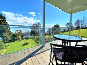 patio con mesa y sillas en el balcón en Addictive View - Lakeside Studio, en Rotorua