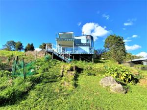 a house sitting on top of a grassy hill at Addictive View - Lakeside Studio in Rotorua