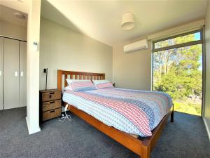 a bedroom with a bed and a window at Addictive View - Lakeside Studio in Rotorua
