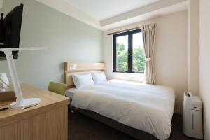 una camera d'albergo con letto e finestra di fico HIJI a Hiji