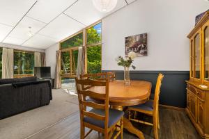 a living room with a table and chairs and a couch at Merioneth Retreat - Arrowtown Holiday Home in Arrowtown
