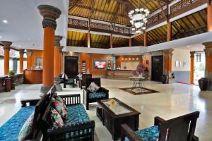a lobby with chairs and a table in a building at Puri Saron Hotel Seminyak in Seminyak