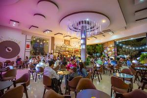 un grupo de personas sentadas en mesas en un restaurante en Sai Gon Dak Nong Hotel, en Gia Nghĩa