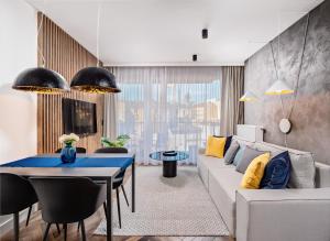sala de estar con sofá blanco y mesa azul en Apartamenty Homely Place - Parking, en Poznan