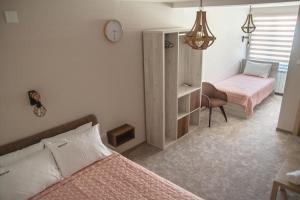 sypialnia z 2 łóżkami i zegarem na ścianie w obiekcie Mehana apartmani w mieście Leskovac