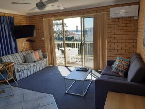 a living room with a couch and a table at Dolphins of Mollymook Motel in Mollymook