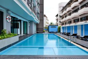 a blue and white swimming pool in a building at Vogue Pattaya Hotel in Pattaya