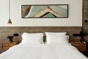 a bedroom with a white bed with a picture on the wall at Whispering Mountains Boutique Hotel in Zhangjiajie +37 photos