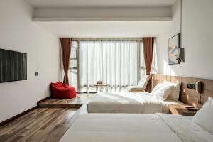 a hotel room with two beds and a window at Whispering Mountains Boutique Hotel in Zhangjiajie