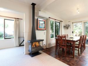a dining room with a fireplace and a table and chairs at Back Beach Hideaway in Blairgowrie