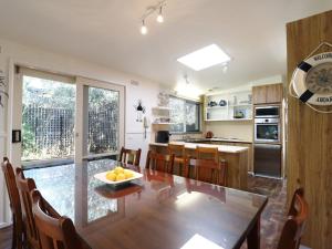 a kitchen with a wooden table and a dining room at Back Beach Hideaway in Blairgowrie +16 photos