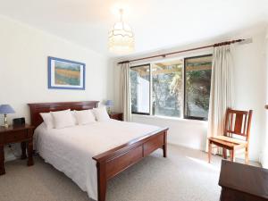a bedroom with a bed and a desk and a window at Back Beach Hideaway in Blairgowrie
