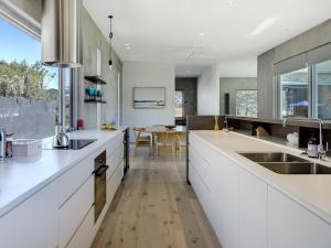 a kitchen with white cabinets and a wooden floor at Amagansett in Sorrento