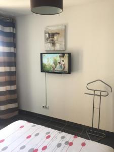 a room with a tv on a white wall at Beau T3 avec terrasse plein sud in Montpellier