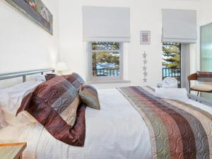 a bedroom with a large bed with pillows on it at Koonya Sur Mer in Sorrento