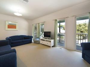 a living room with a blue couch and a tv at Poolside Sorrento in Sorrento
