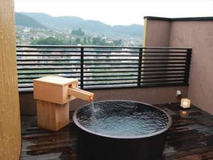 a bath tub with a fountain on a balcony at Ryokan Biyunoyado in Yamanouchi