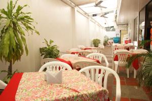 a row of tables and chairs in a restaurant at Hotel Mar Azul by Croma in Santa Marta