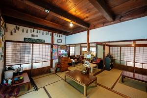 a living room with wooden ceilings and a table at Momonga Village in Miyoshi