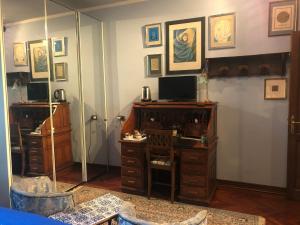 Zimmer mit einem Spiegel, einem Schreibtisch und einem TV. in der Unterkunft B&B Les Fleurettes in Lomazzo